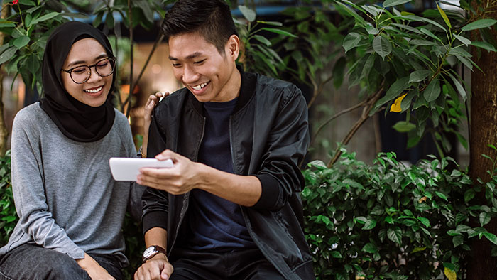 young man showing a woman his phone