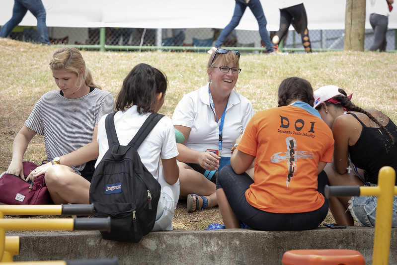 Five women sitting together on the ground 