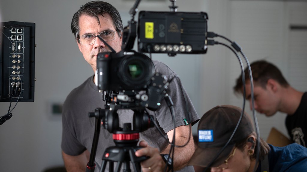 Man standing behind movie camera